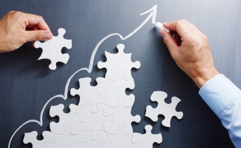 Growing puzzle pieces on chalkboard